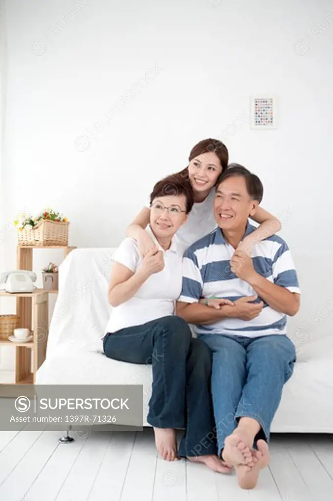Parents with daughter looking away with smile together
