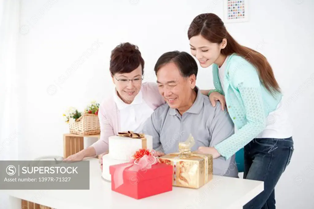 Parents with daughter looking at the gifts and smiling happily together