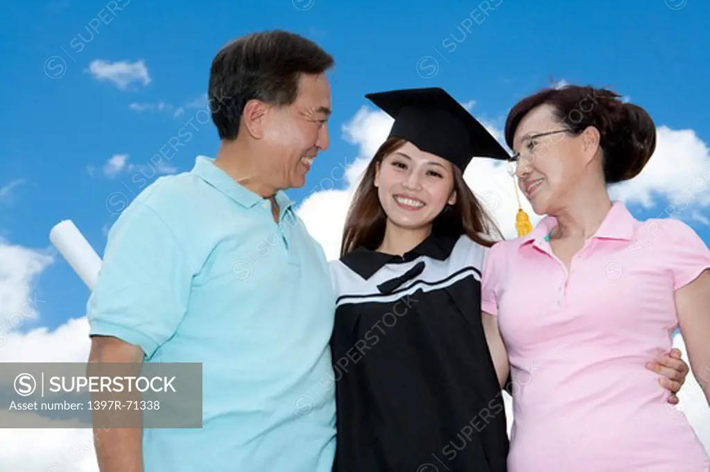 Parents with daughter standing together and smiling happily