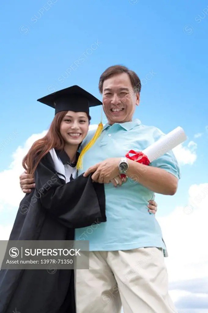 Father and daughter embracing and smiling on graduation