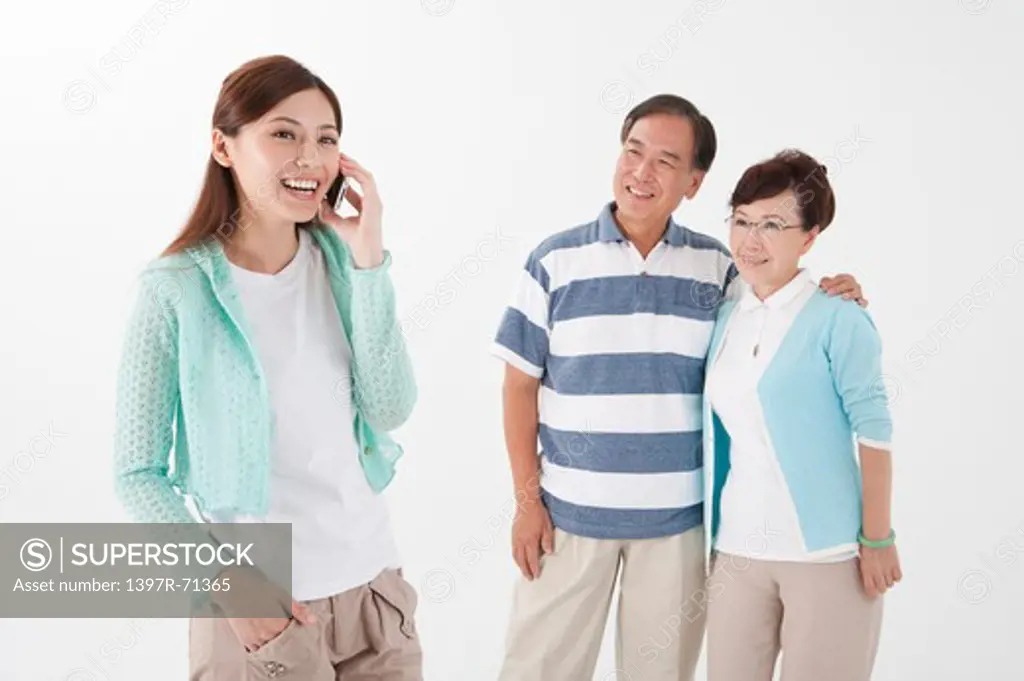Parents standing together with daughter on the phone
