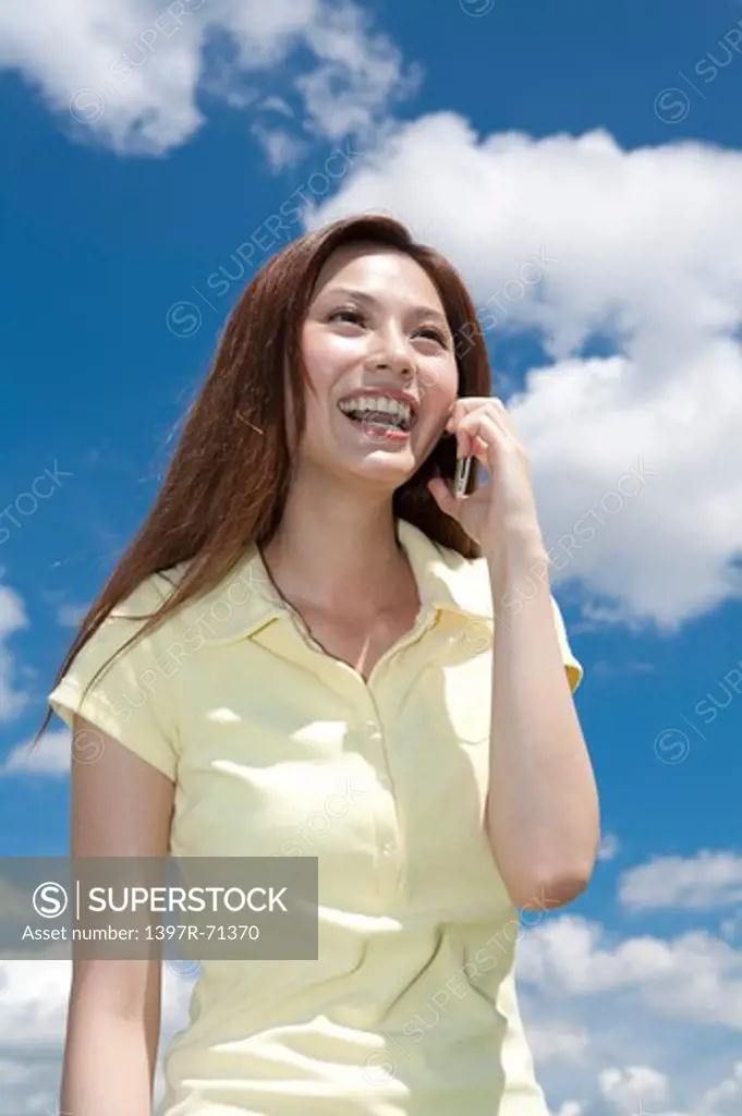 Young woman smiling happily and on the phone