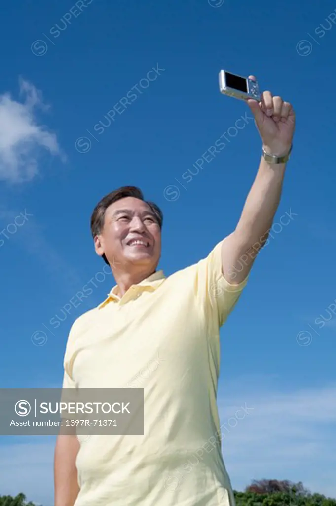 Senior man taking picture and smiling happily