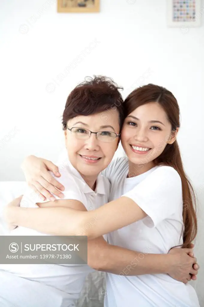 Mother and daughter embracing and smiling together