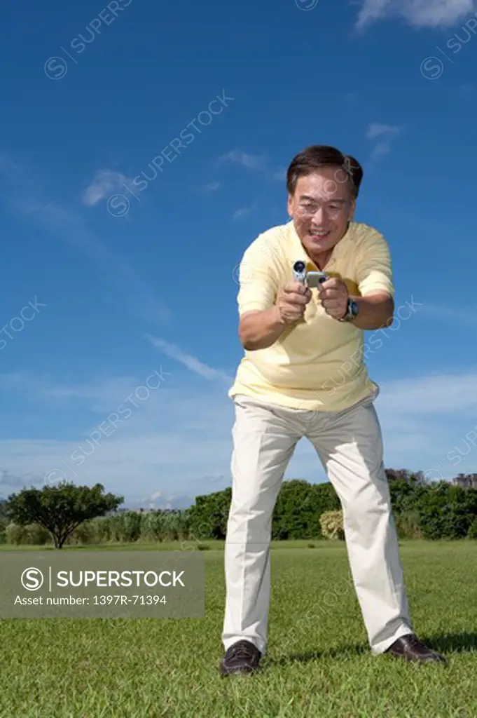 Senior man holding camera and taking picture with smile