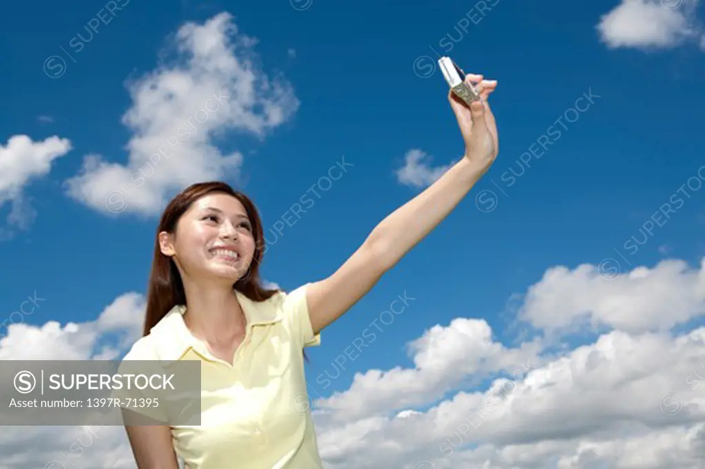 Young woman holding camera and taking picture with smile