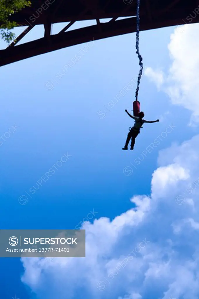 Woman bungee jumping from a bridge