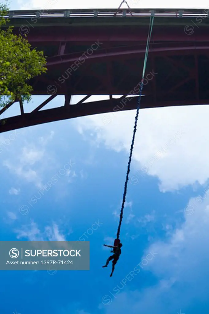 Man bungee jumping from a bridge