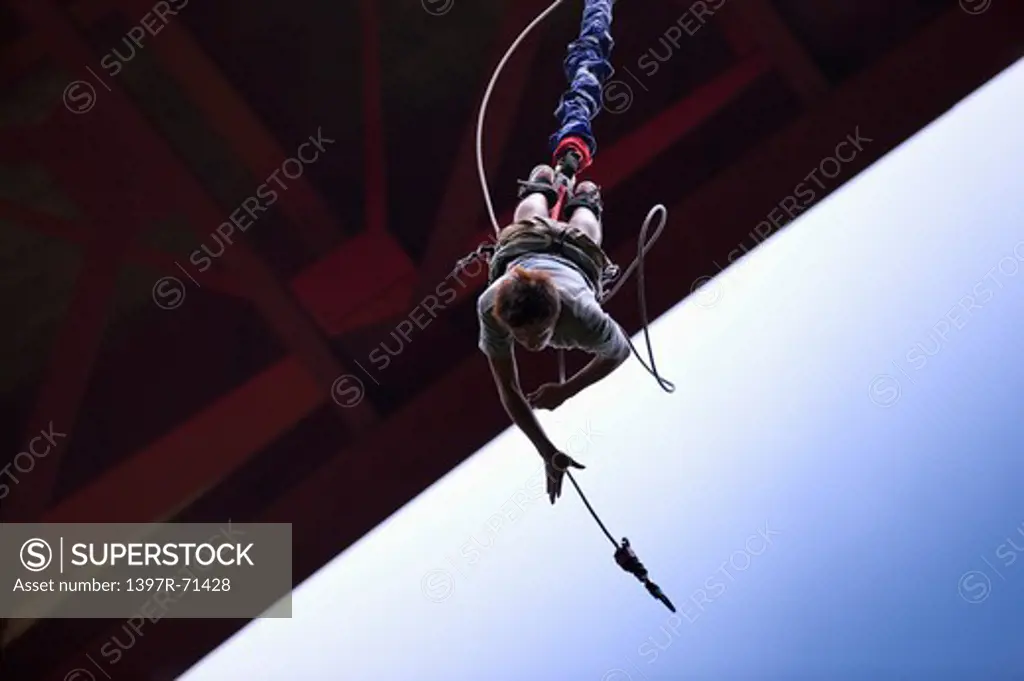 Man bungee jumping from a bridge