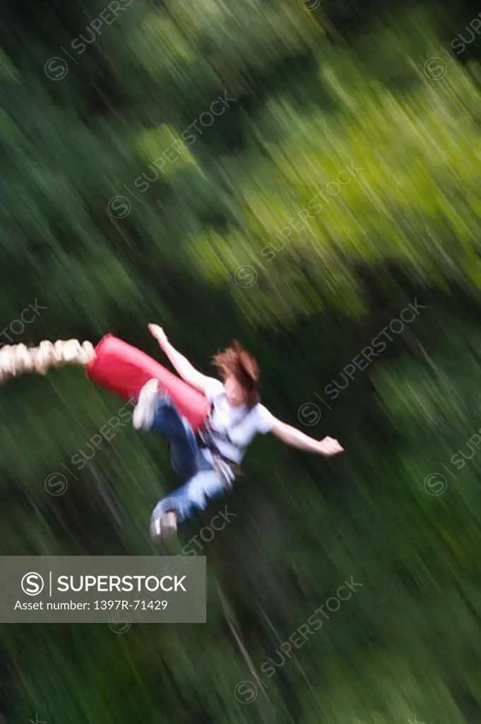 Woman bungee jumping with arms outstretched
