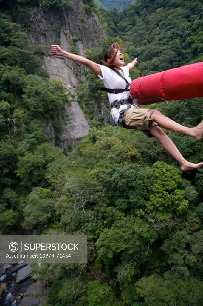 Female bungee jumper falling backwards and shouting