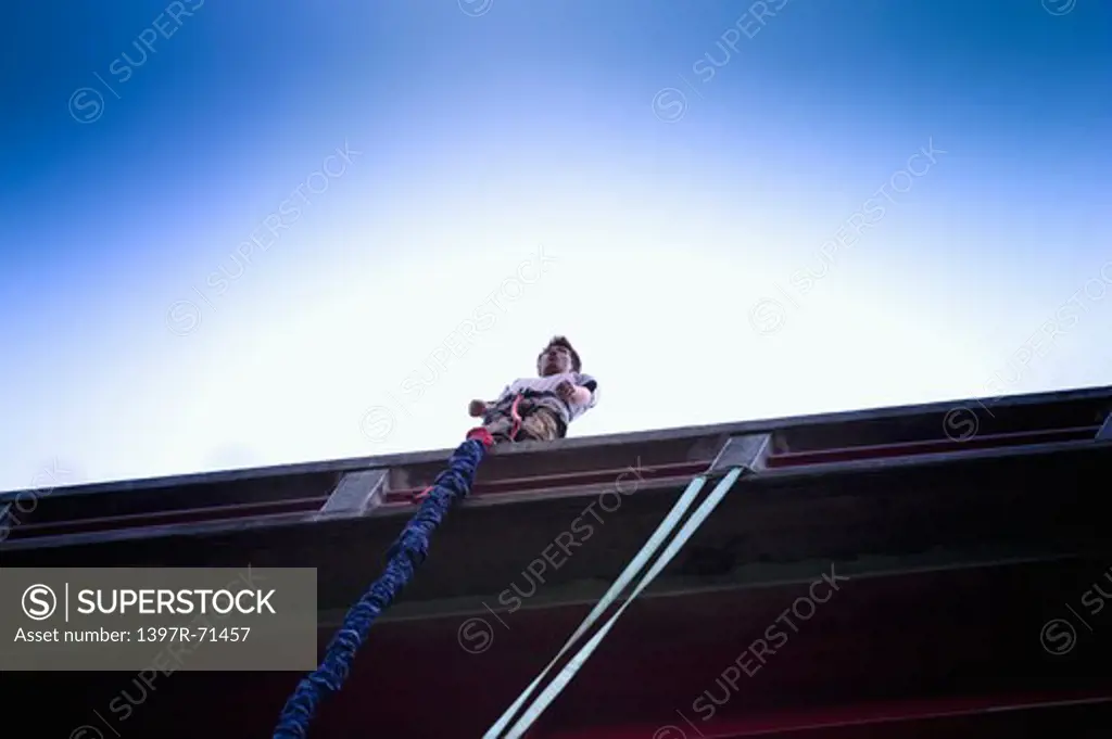 Bungee jumper standing on a bridge about to jump, low angle view