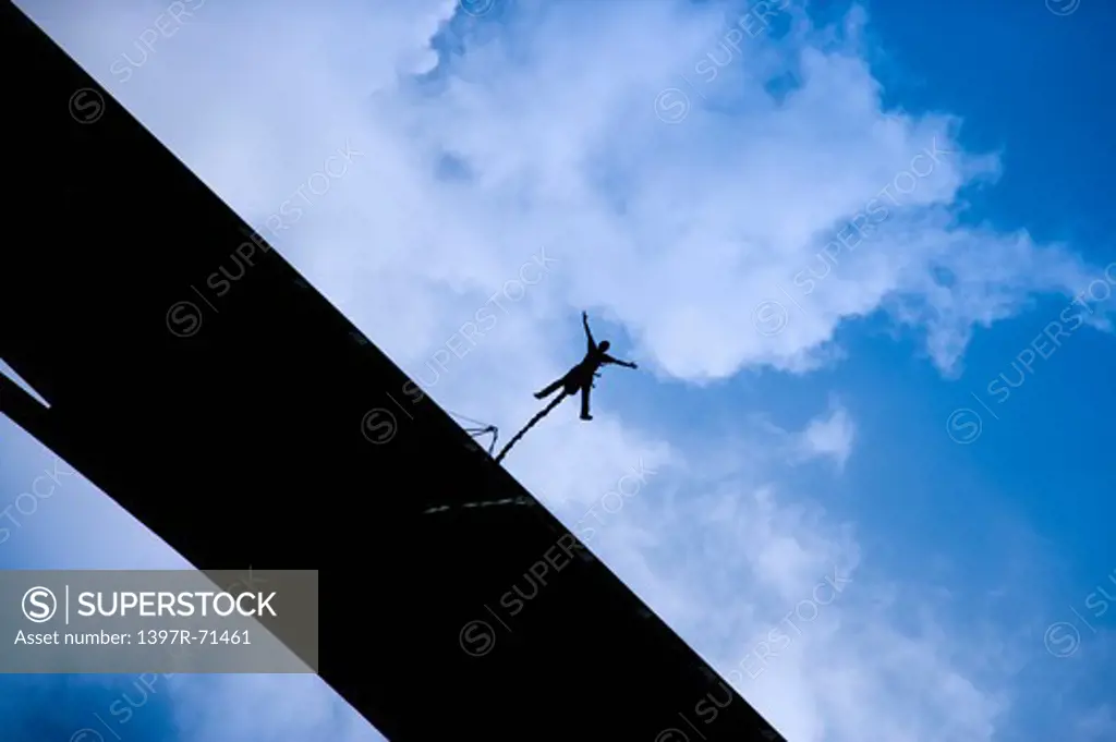 Bungee jumper falling from a bridge, low angle view