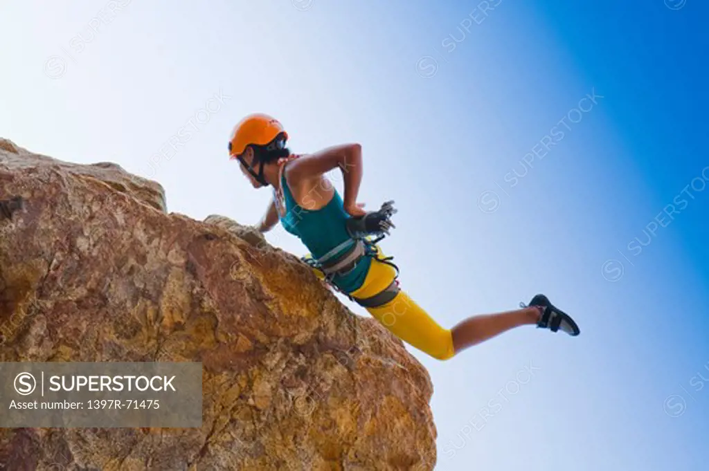 Woman rock climbing on cliffs