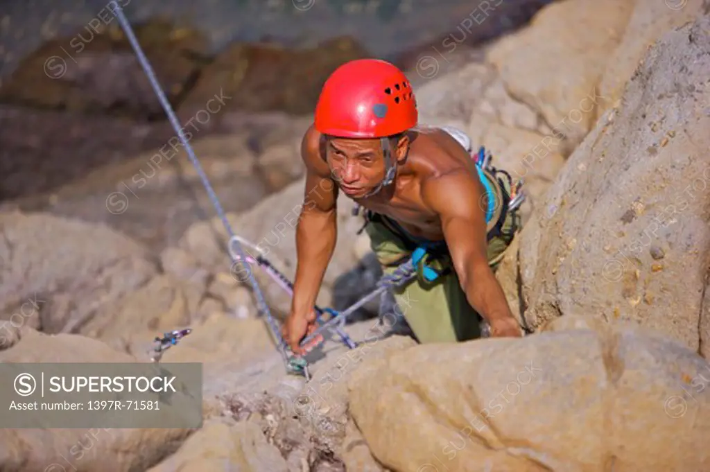 Man rock climbing on cliffs, high angle view