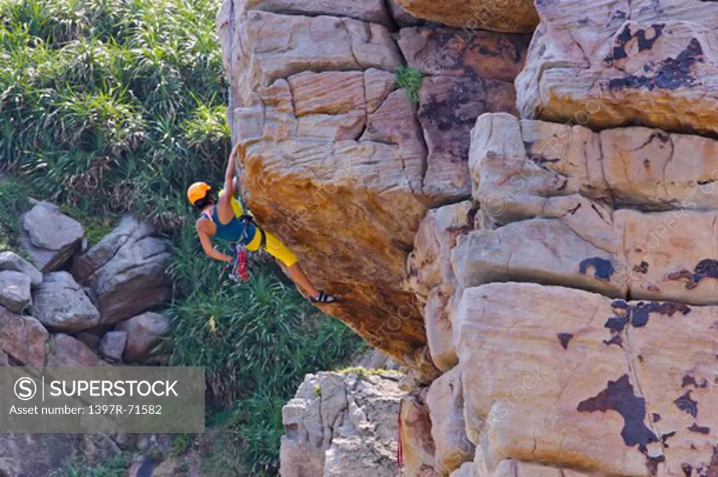 Woman rock climbing on cliffs