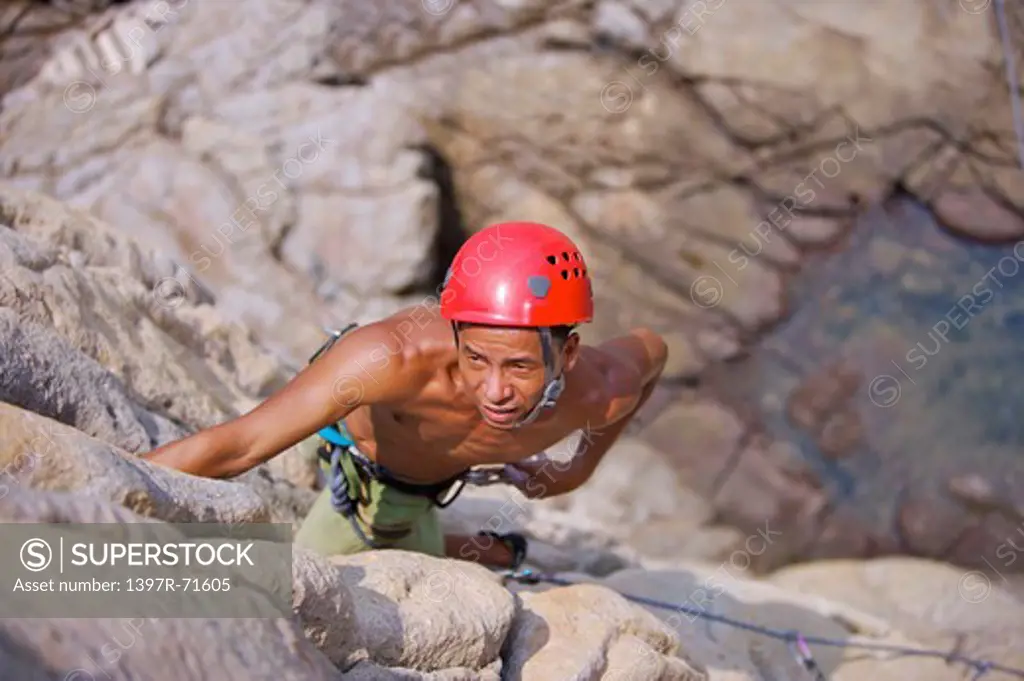Man rock climbing on cliffs, high angle view