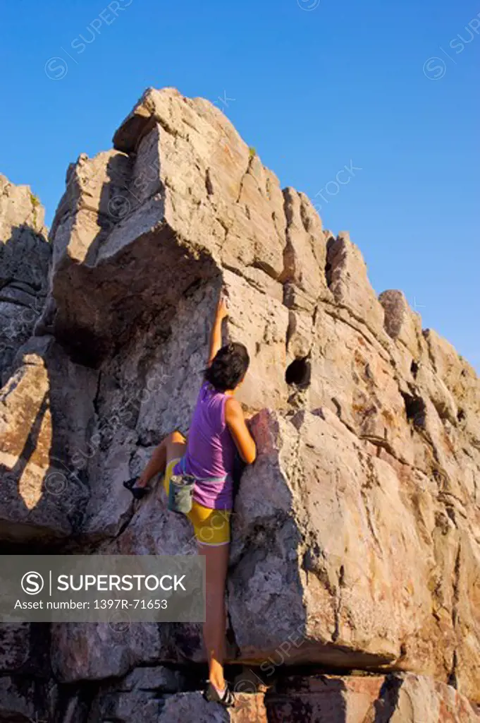 Mid adult woman climbing on the cliff, Rock Climbing, Extreme Sports