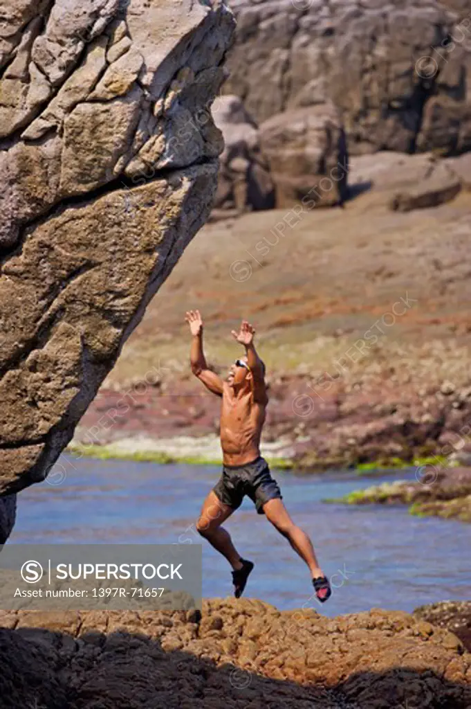 Mature man jumping in mid-air, Rock Climbing, Extreme Sports