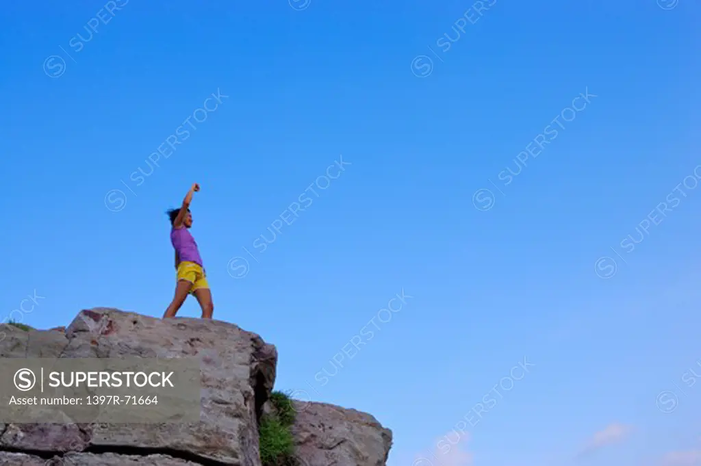 Mid adult woman standing on the top of cliff, Rock Climbing, Extreme Sports