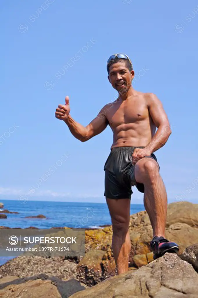 Mature man standing on the rock with thumbs up, Rock Climbing, Extreme Sports