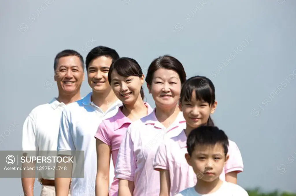 Multi-generational family standing in a line, smiling