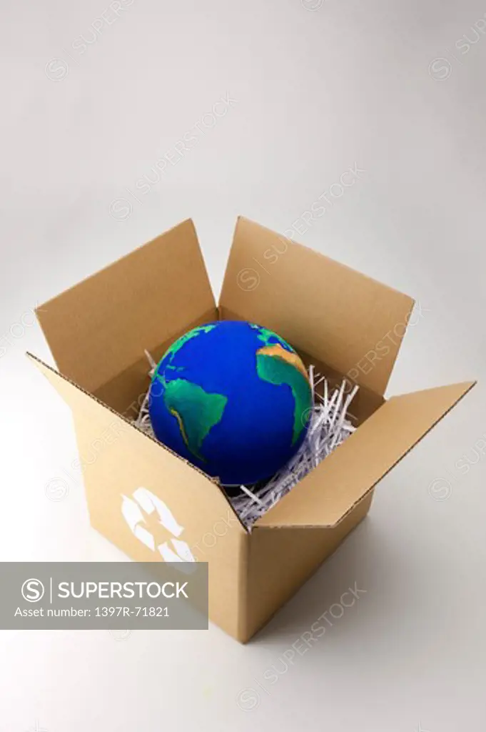 A globe in an open recycling cardboard box