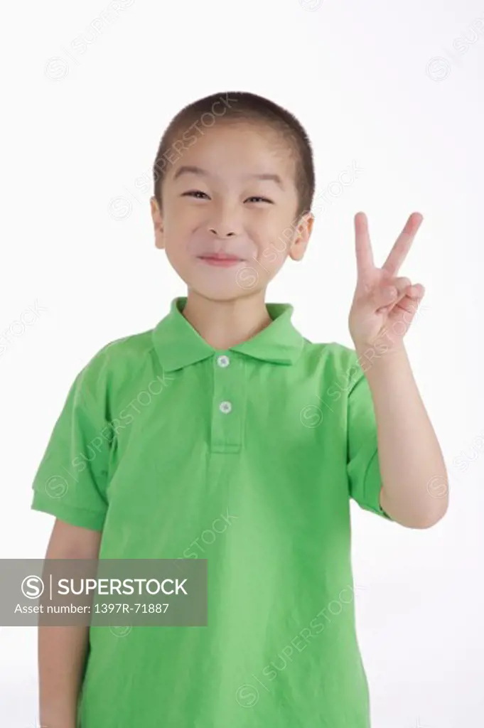 Boy looking away and smiling with two fingers