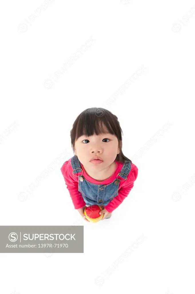 Little girl holding a small ball and looking up to camera