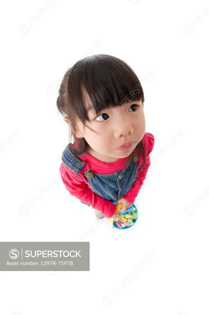 Little girl holding toys and looking upward