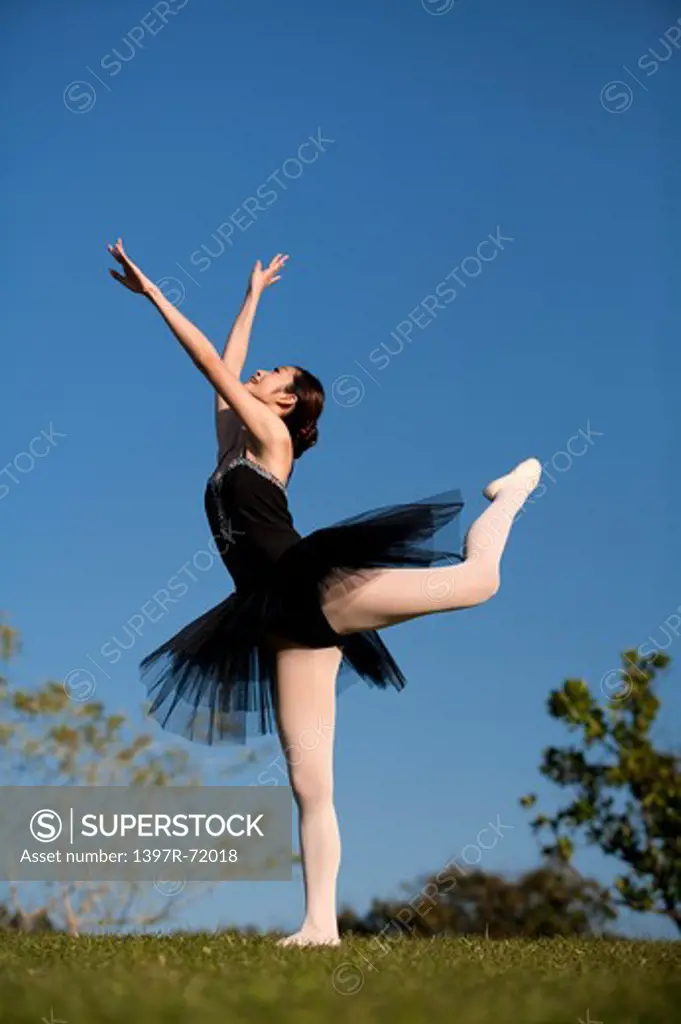 Ballet dancer dancing on the lawn with head back