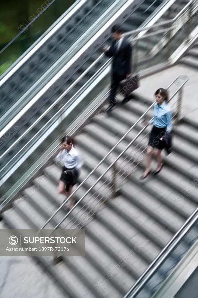 Business people hurrying down the stairs, blurred motion, elevated view