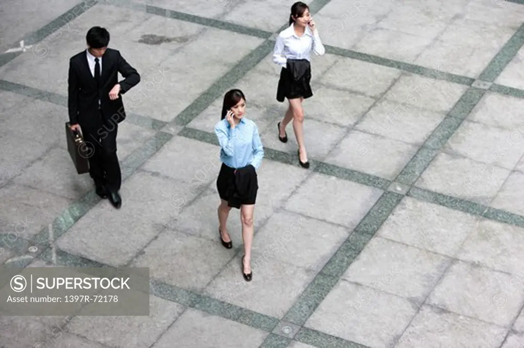Business team walking in a hurry and talking on the phone, elevated view