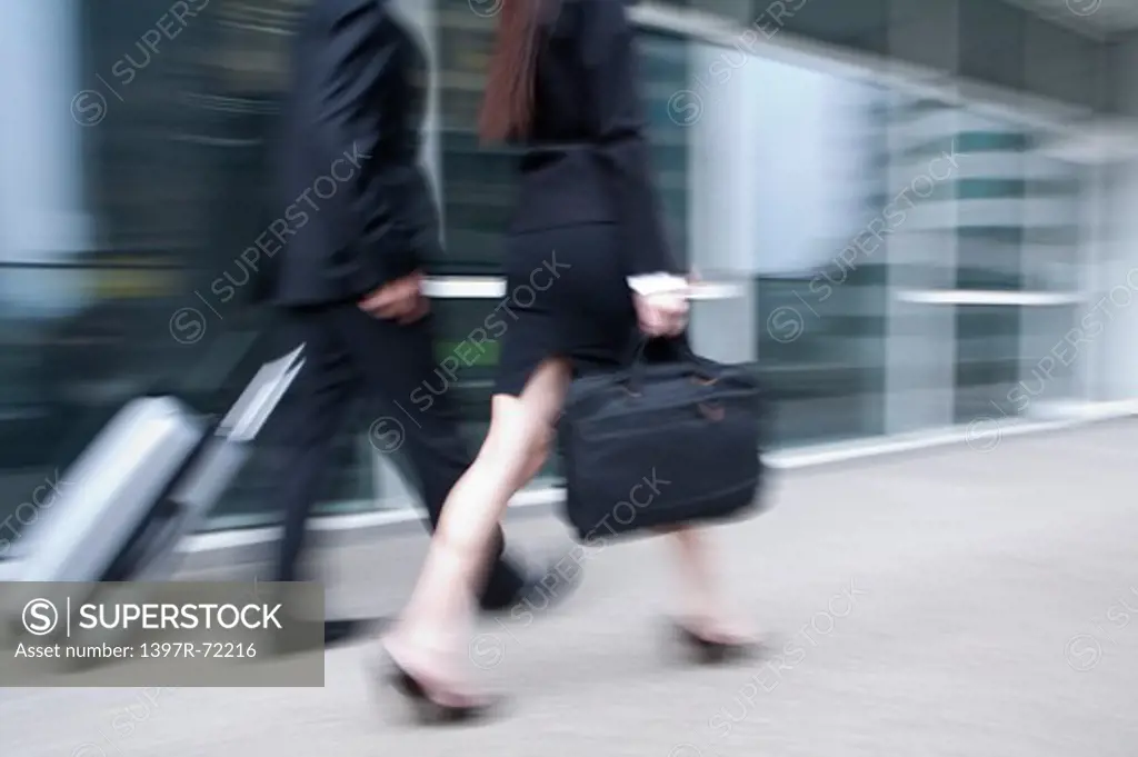 Business people walking in a hurry, blurred motion