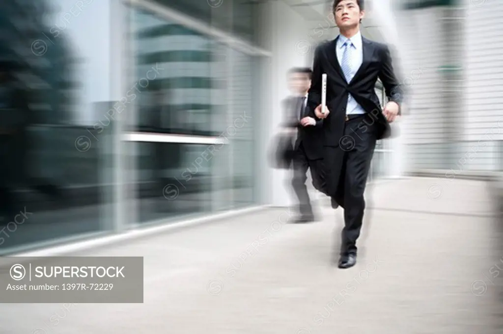 Businessmen running, blurred motion