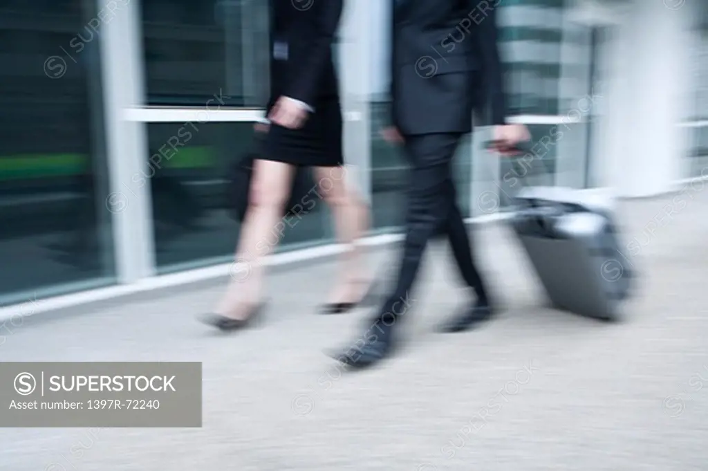 Business people walking in a hurry, blurred motion