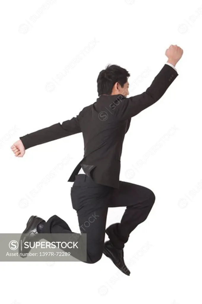 Businessman jumping with arms outstretched and feet up