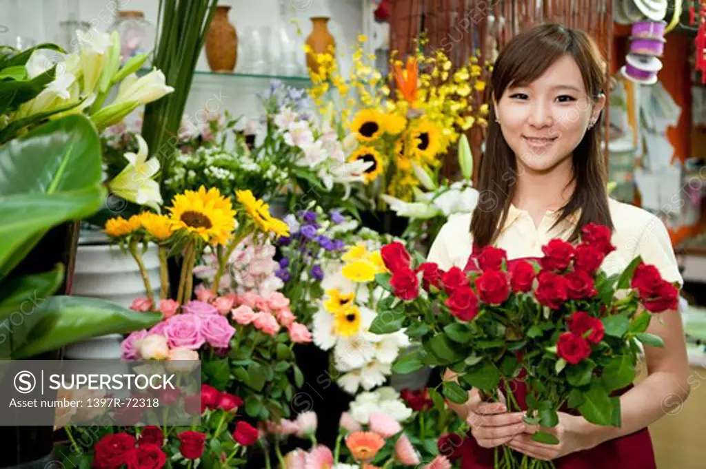 Female florist holding a bunch of rose in the flower shop