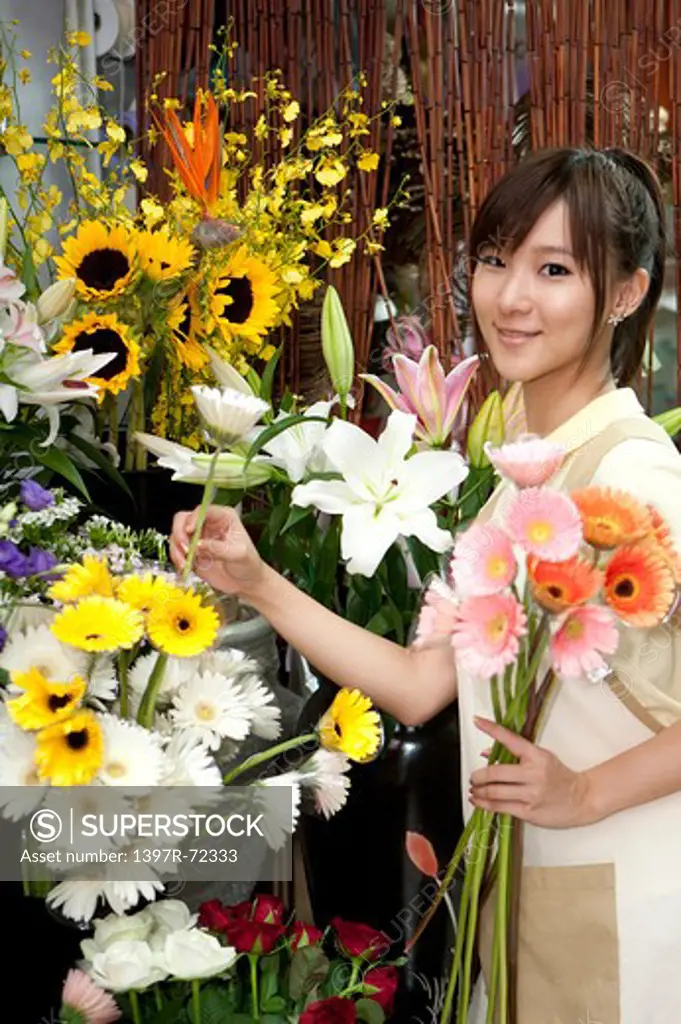 Female florist choosing flowers to put into a bunch in the flower shop