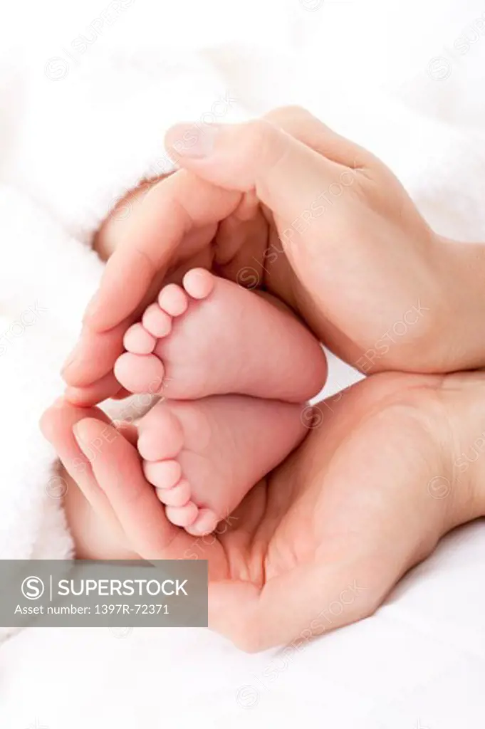 Mother's hands cradling baby's feet