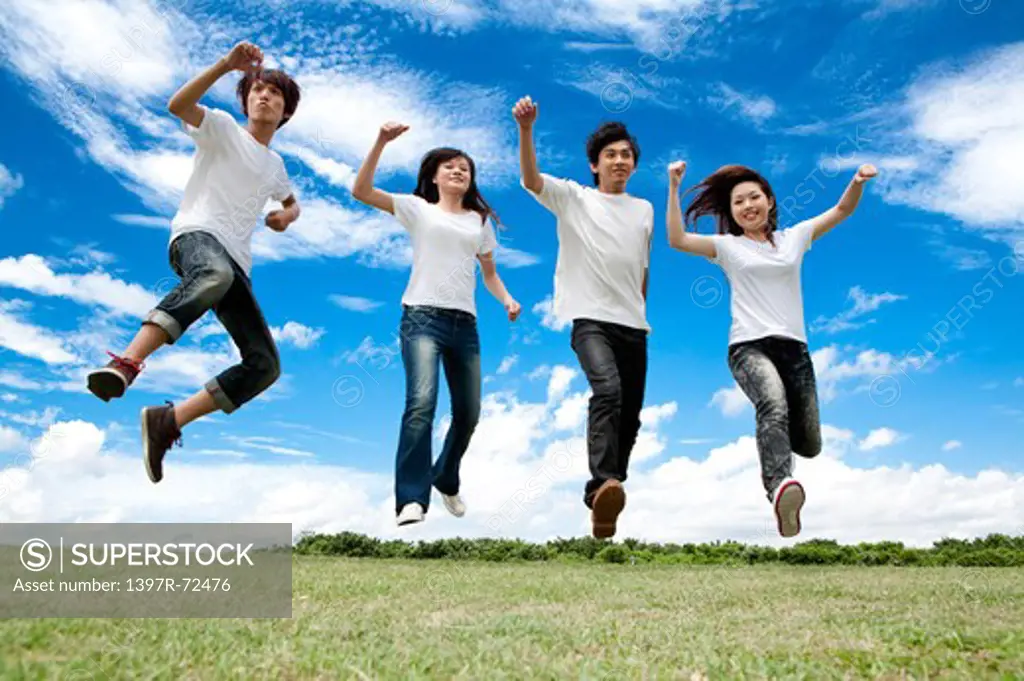 Young adults jumping in mid-air with smile