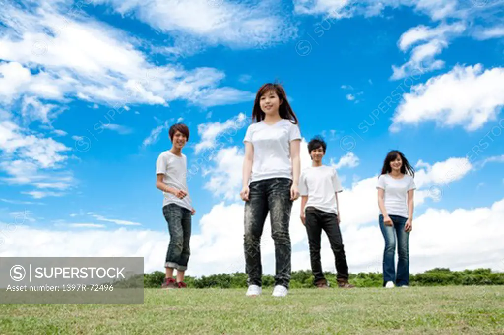 Young adults standing on the lawn and smiling