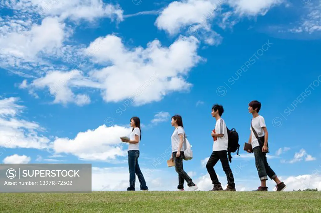Young adults walking on the lawn together