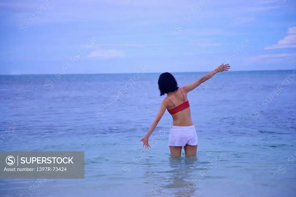 Balicasag Island, Cebu, Philippines, Asia, Woman standing in water with arms outstretched