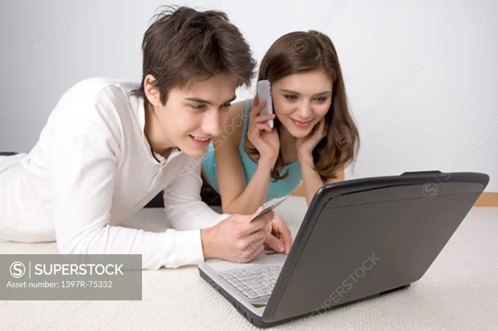 Young couple paying bills on line with credit card