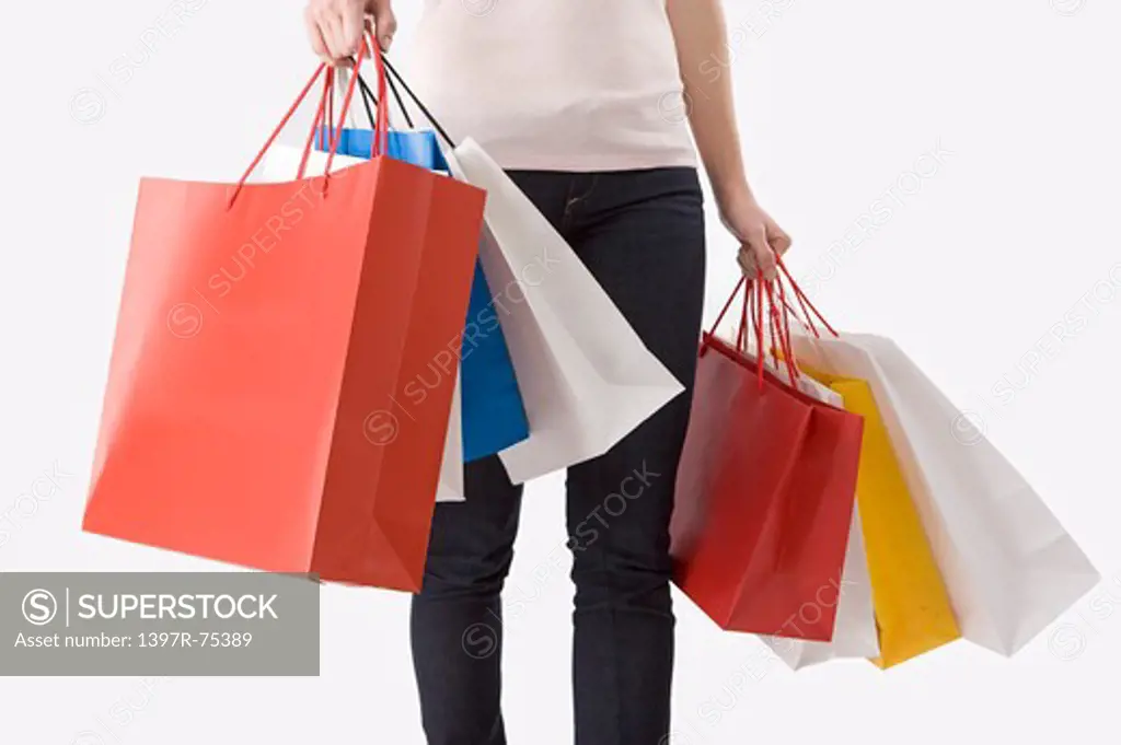 Young woman holding shopping bags in both hands, Shopping