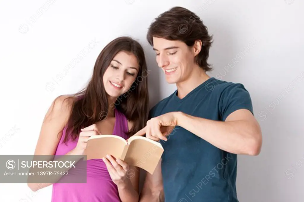 Young couple reading a book