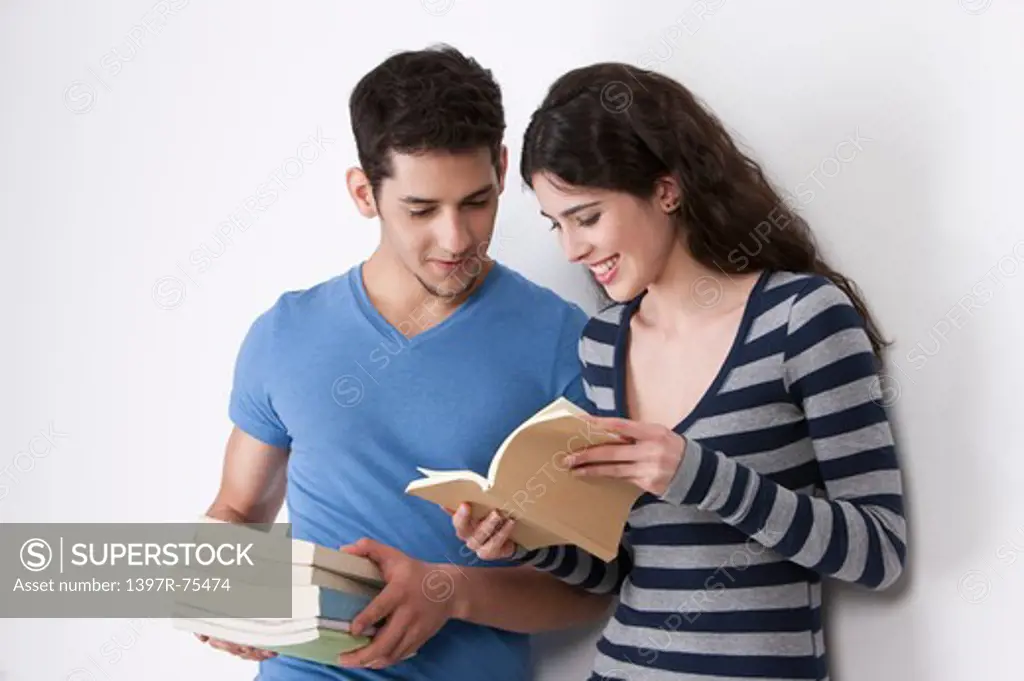 Young couple reading books, smiling