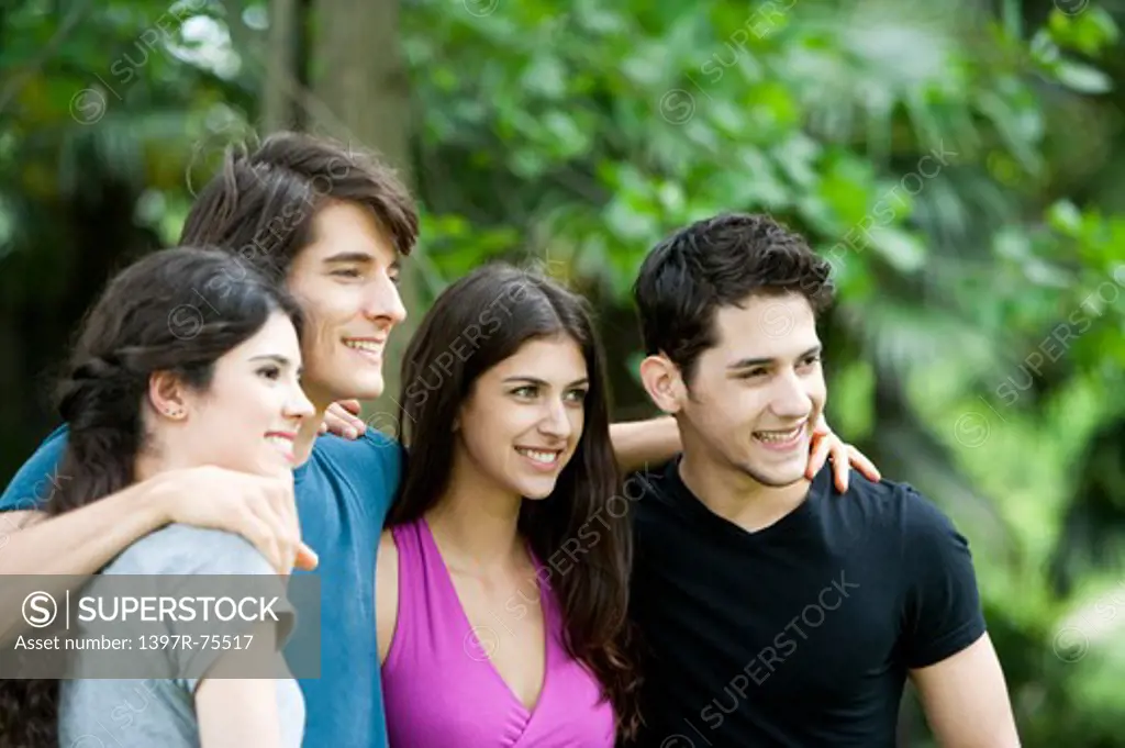 Four young friends arm in arm smiling