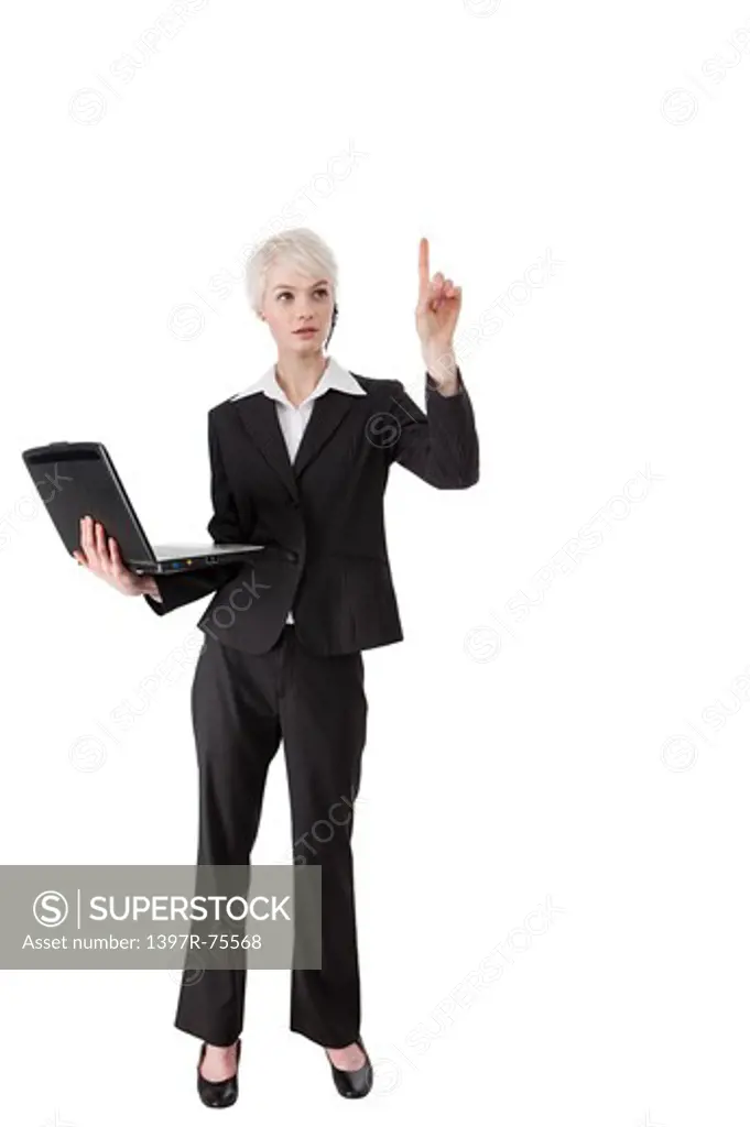 Young woman holding laptop, touching and looking up